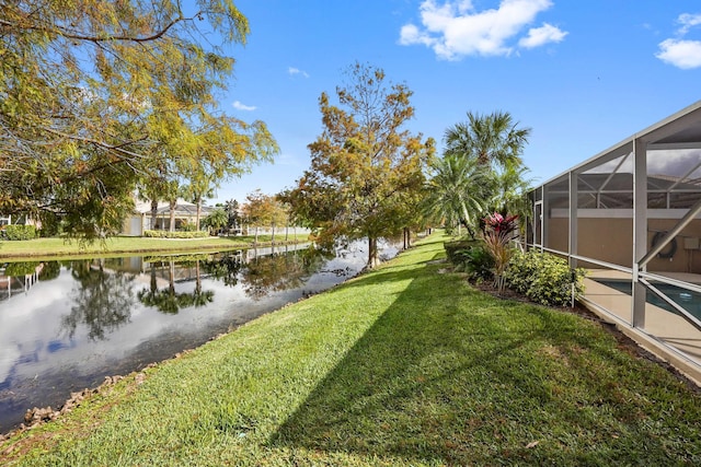 view of yard with glass enclosure and a water view