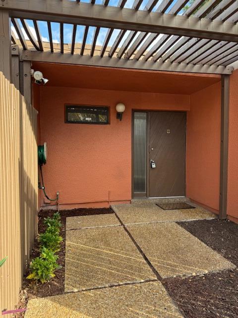 entrance to property with a pergola and a patio area