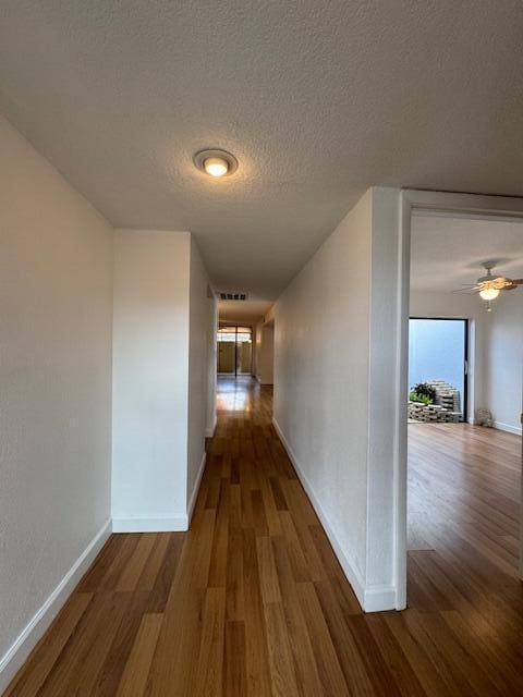 hall with dark hardwood / wood-style floors and a textured ceiling