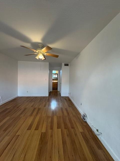 unfurnished room with ceiling fan and dark hardwood / wood-style flooring