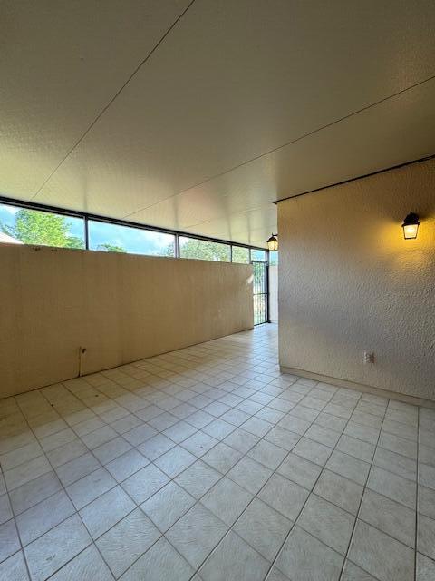 tiled spare room featuring plenty of natural light