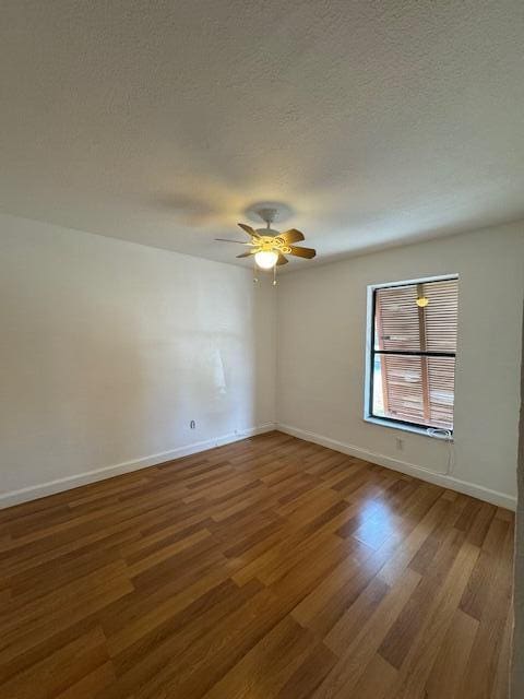 empty room with ceiling fan, hardwood / wood-style floors, and a textured ceiling