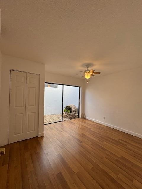 spare room featuring ceiling fan, wood-type flooring, and a textured ceiling