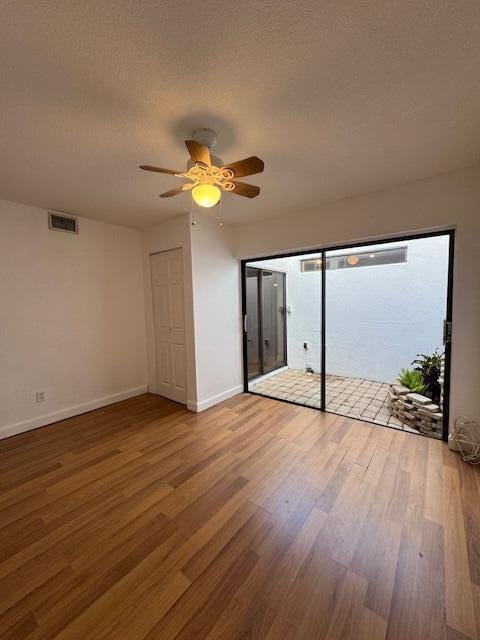 spare room with ceiling fan, wood-type flooring, and a textured ceiling