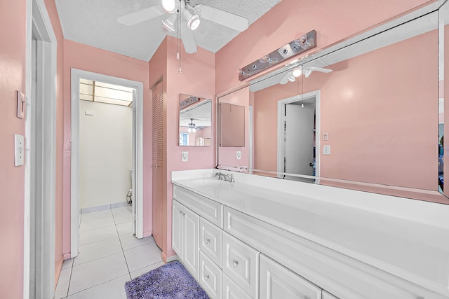 bathroom featuring tile patterned floors, vanity, toilet, and a textured ceiling