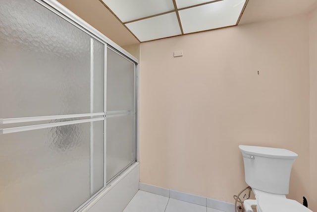 bathroom with shower / bath combination with glass door, tile patterned floors, and toilet