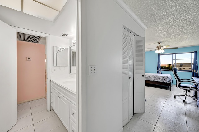 corridor with light tile patterned flooring and a textured ceiling