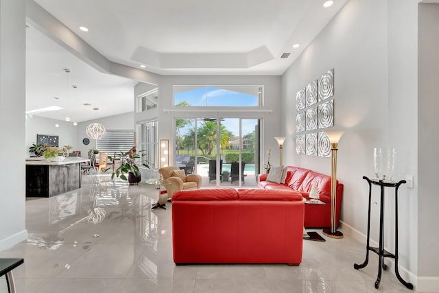 living room with a raised ceiling and a high ceiling