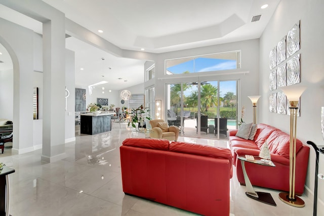 living room with a high ceiling and a tray ceiling