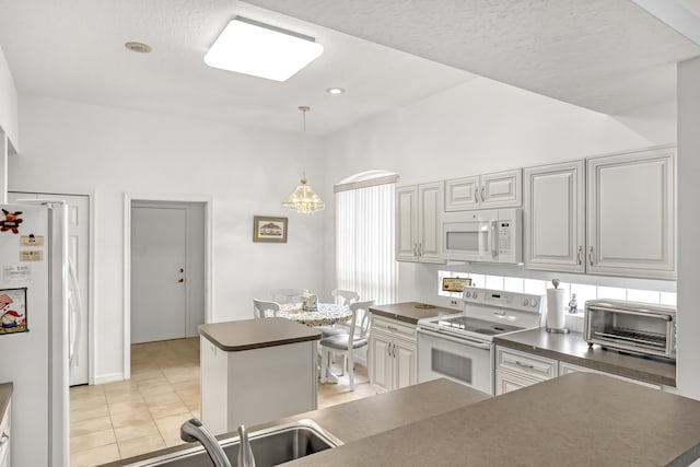 kitchen with lofted ceiling, a center island, white appliances, and decorative light fixtures