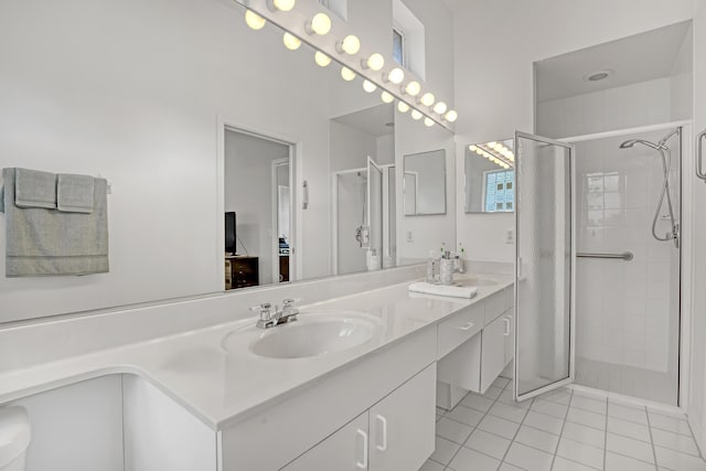 bathroom with double vanity, tile patterned flooring, a sink, and a shower stall