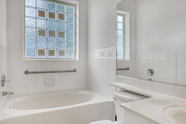 bathroom featuring toilet, a tub, and sink