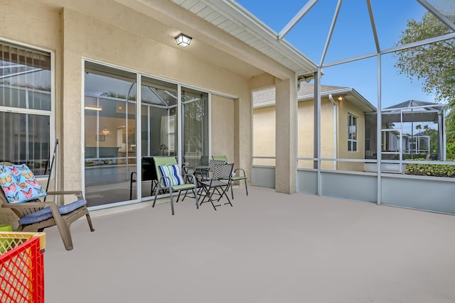 view of patio featuring glass enclosure