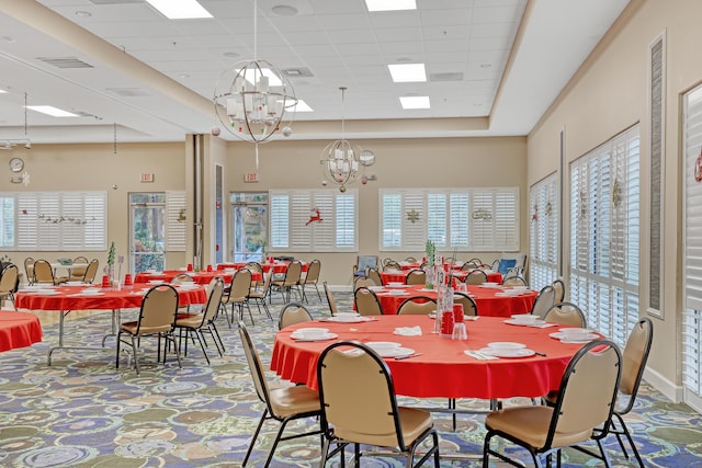 dining space with a paneled ceiling, baseboards, visible vents, and a chandelier