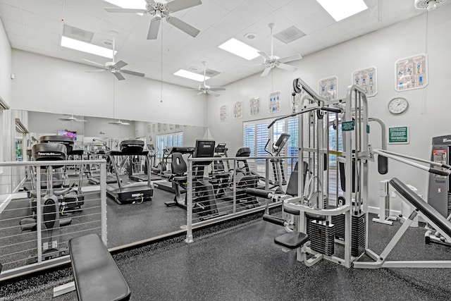 exercise room featuring a high ceiling, a drop ceiling, and visible vents