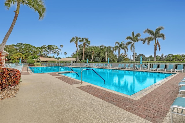 pool with a patio area and fence