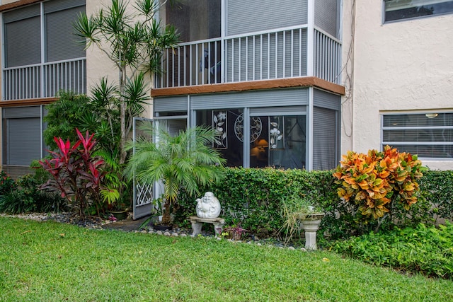 doorway to property featuring a lawn