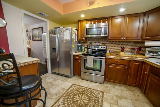 kitchen with stainless steel appliances and decorative backsplash