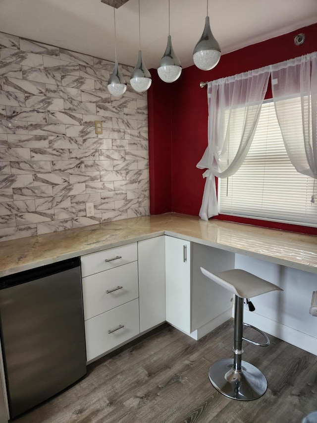 kitchen with dark hardwood / wood-style floors, white cabinetry, hanging light fixtures, and stainless steel refrigerator