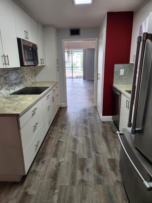 kitchen featuring white cabinets, dark hardwood / wood-style floors, backsplash, and stainless steel appliances