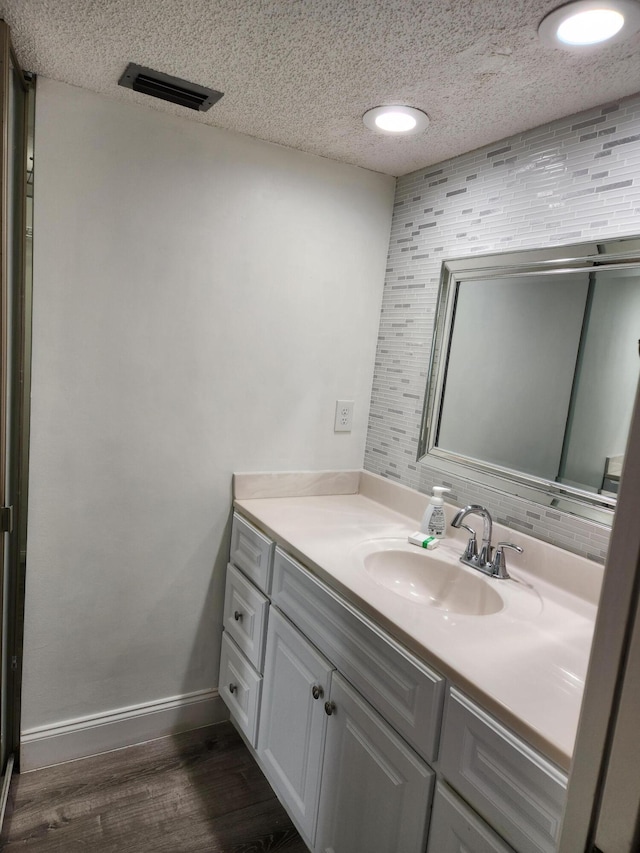 bathroom featuring vanity, wood-type flooring, and a textured ceiling