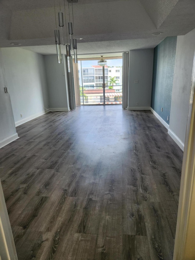 unfurnished room with dark hardwood / wood-style floors and a textured ceiling