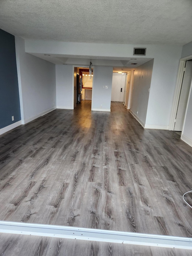 unfurnished living room with a textured ceiling and hardwood / wood-style flooring