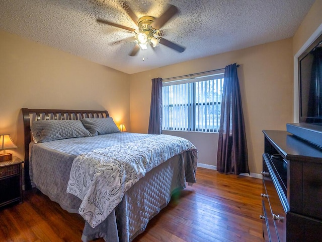 bedroom featuring a textured ceiling, dark hardwood / wood-style floors, and ceiling fan