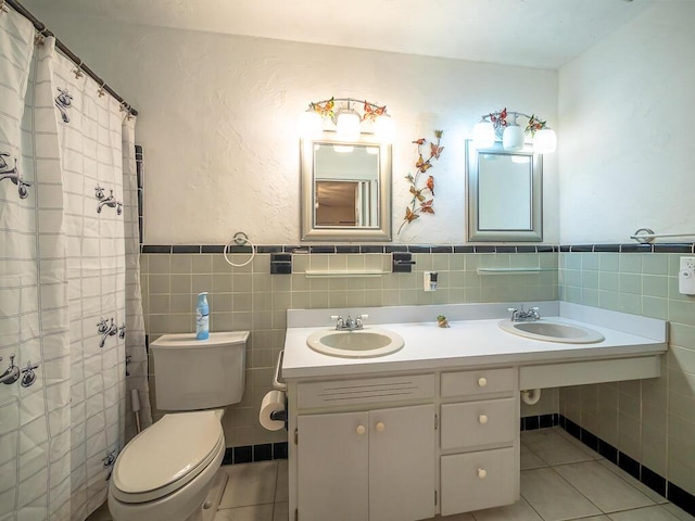 bathroom with tile patterned flooring, toilet, sink, and tile walls