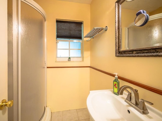 bathroom featuring tile patterned flooring, walk in shower, and sink