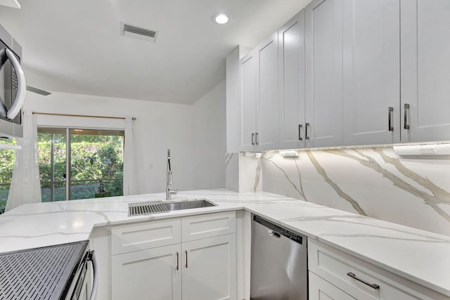 kitchen with appliances with stainless steel finishes, white cabinetry, and sink