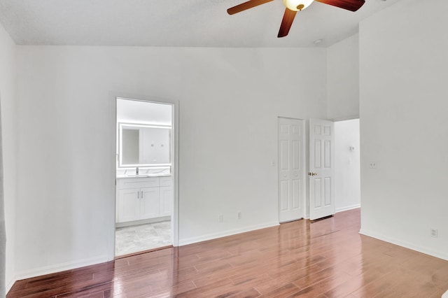 spare room with light wood-type flooring, vaulted ceiling, ceiling fan, and sink