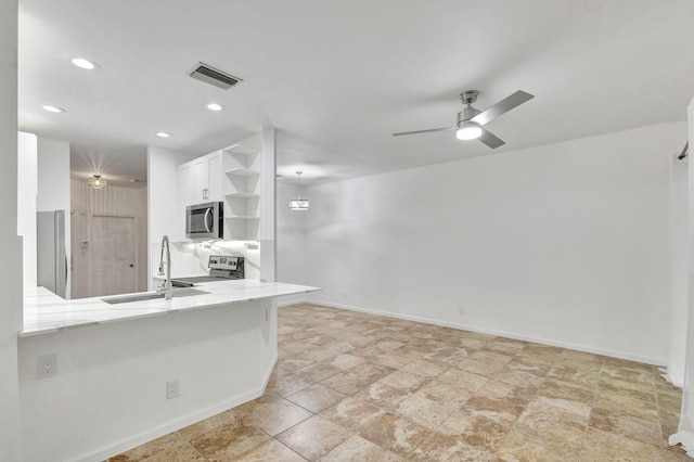 kitchen featuring kitchen peninsula, stainless steel appliances, ceiling fan, sink, and white cabinets