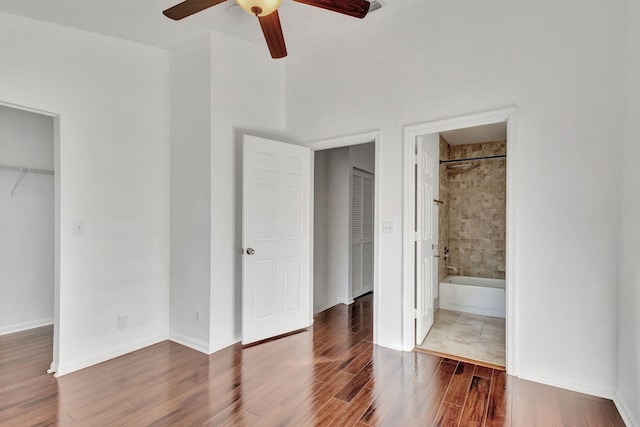 unfurnished bedroom featuring connected bathroom, ceiling fan, and wood-type flooring