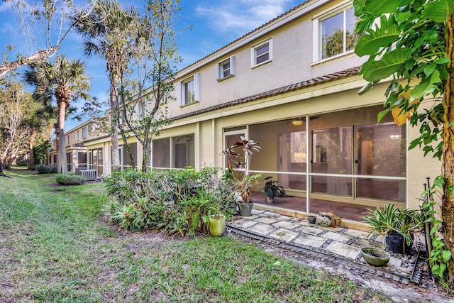 back of property featuring a yard and central air condition unit