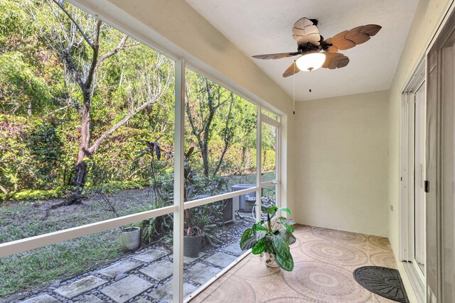 unfurnished sunroom featuring ceiling fan