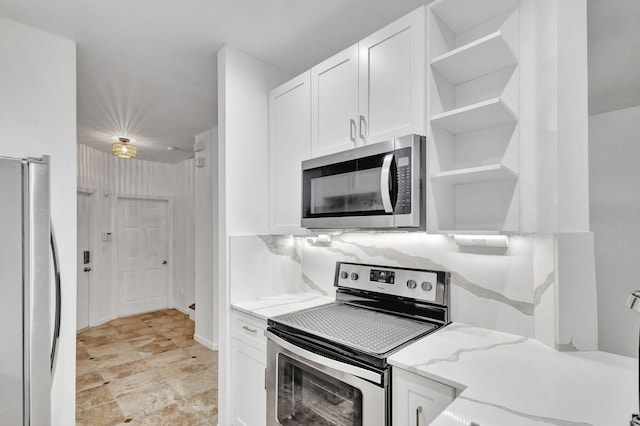 kitchen with white cabinets, decorative backsplash, stainless steel appliances, and light stone counters