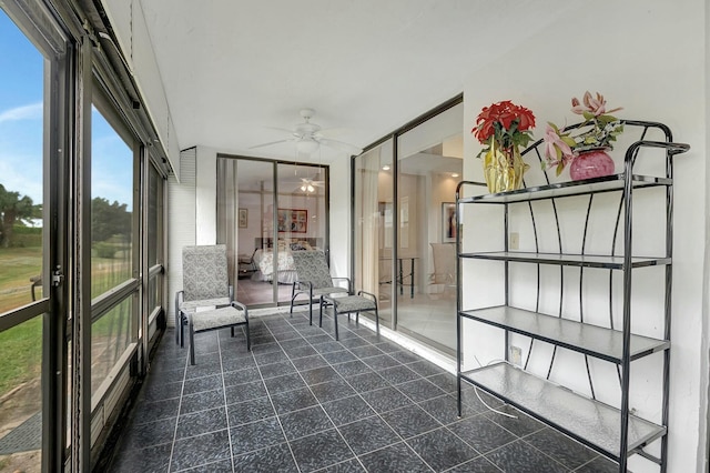 unfurnished sunroom featuring ceiling fan