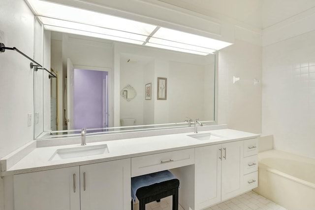 bathroom featuring toilet, vanity, a bathtub, and tile patterned floors