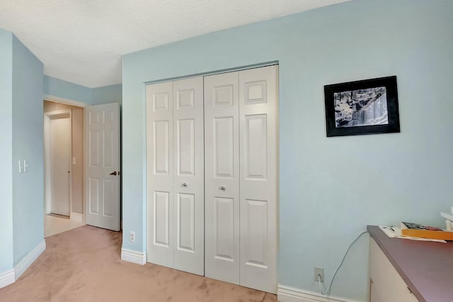 bedroom with light carpet, a closet, and a textured ceiling