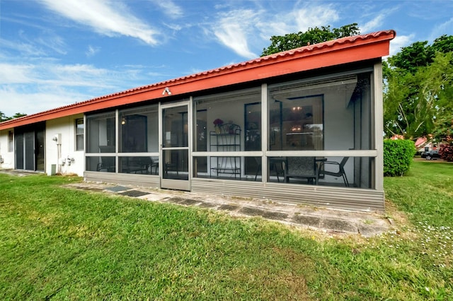 back of house featuring a sunroom and a yard