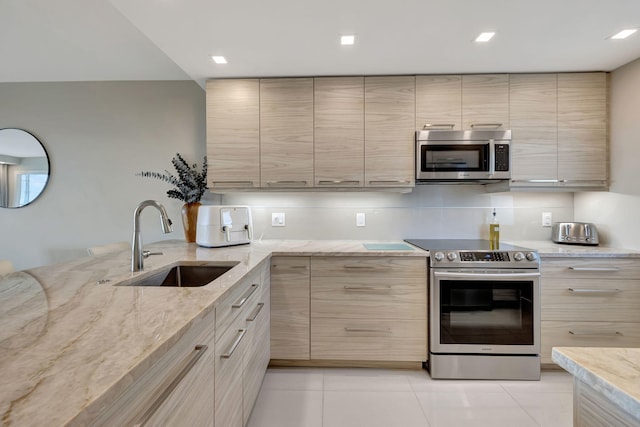 kitchen featuring sink, light brown cabinets, light stone countertops, and appliances with stainless steel finishes