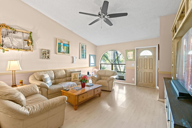 living room featuring a textured ceiling, light hardwood / wood-style floors, ceiling fan, and lofted ceiling