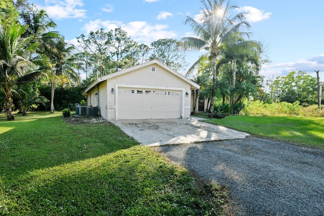 exterior space featuring cooling unit, a front yard, and a garage