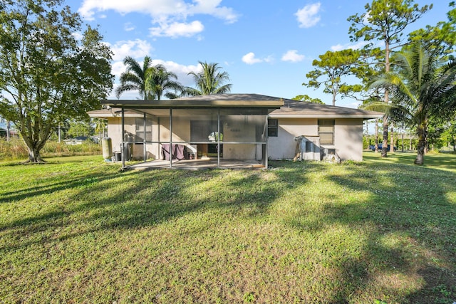 rear view of property featuring a sunroom and a yard