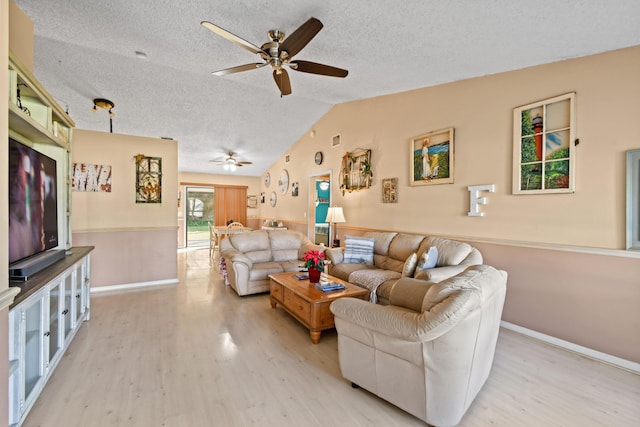 living room featuring a textured ceiling, light hardwood / wood-style flooring, vaulted ceiling, and ceiling fan