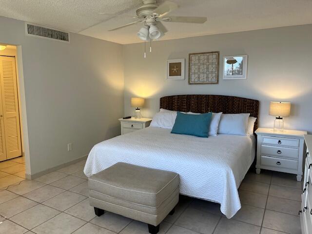 bedroom featuring ceiling fan, a closet, and light tile patterned floors