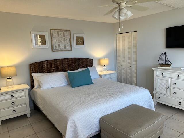 bedroom featuring ceiling fan, a closet, and light tile patterned floors