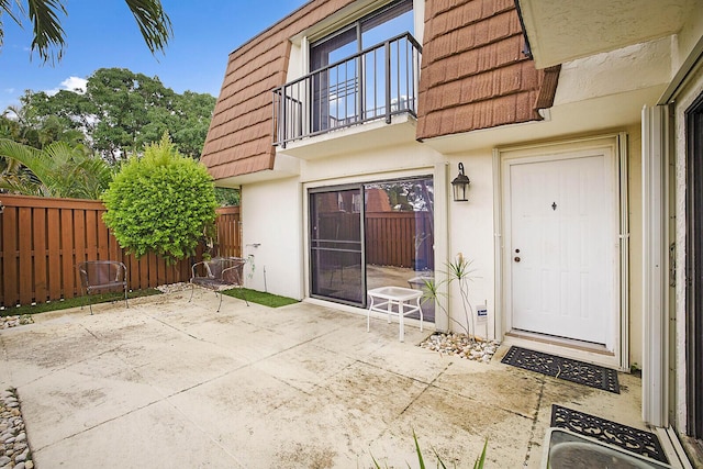 property entrance with a patio and a balcony