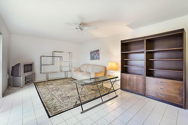 tiled home office with ceiling fan and a textured ceiling